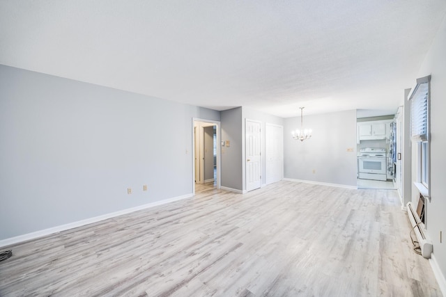 unfurnished living room featuring an inviting chandelier and light wood-type flooring