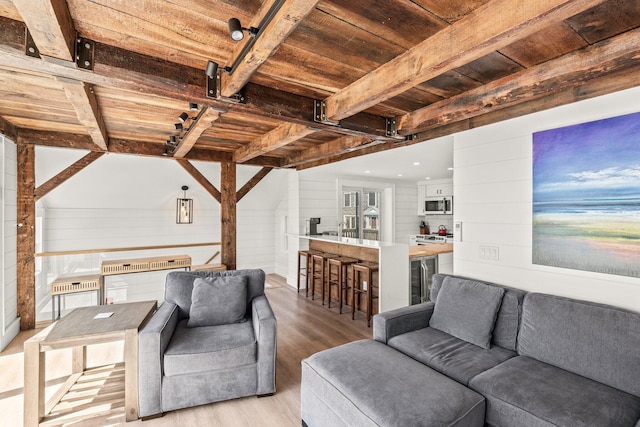 living room with wooden walls, lofted ceiling with beams, light hardwood / wood-style flooring, and wood ceiling