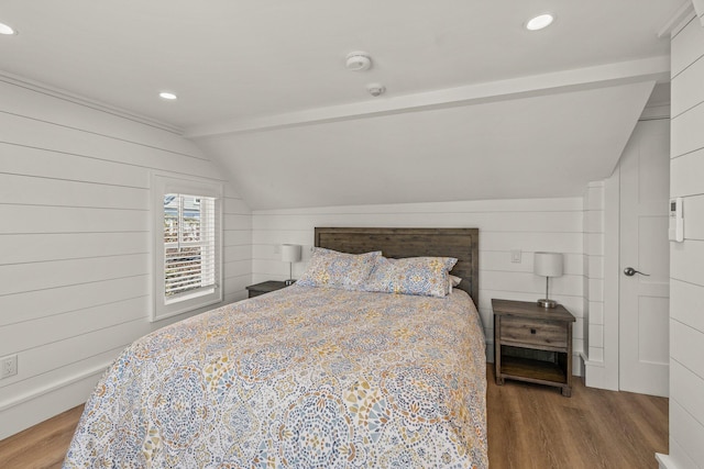 bedroom featuring wood walls, light hardwood / wood-style flooring, and vaulted ceiling