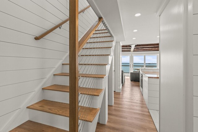 stairway featuring hardwood / wood-style flooring and a water view