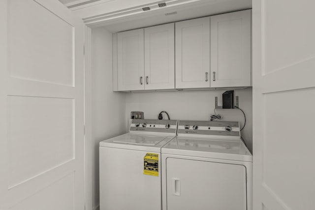 washroom featuring cabinets and independent washer and dryer