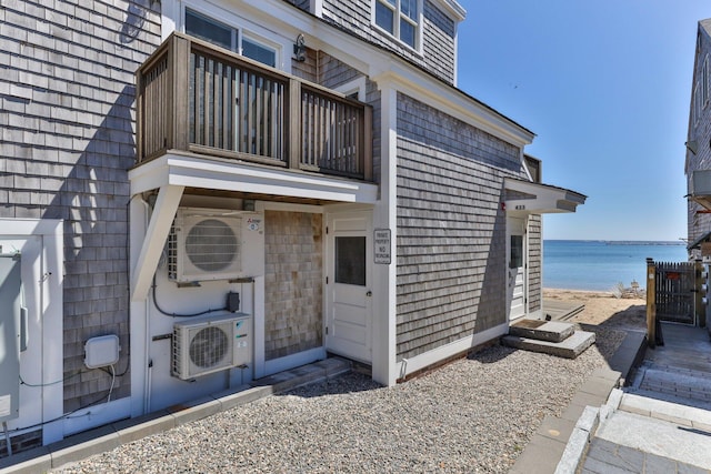 view of exterior entry with ac unit and a water view