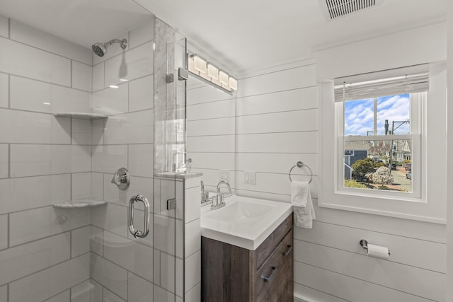 bathroom with a shower with door, wooden walls, and vanity