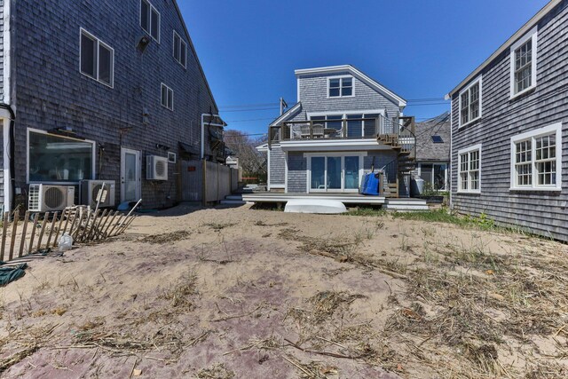 back of property featuring a balcony, ac unit, and a wall mounted air conditioner