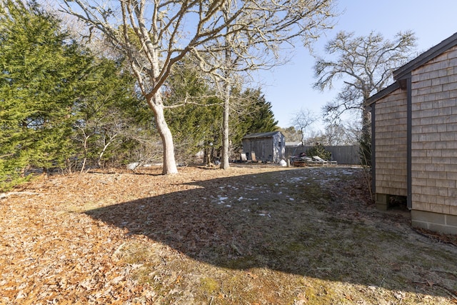 view of yard featuring a storage unit and an outbuilding