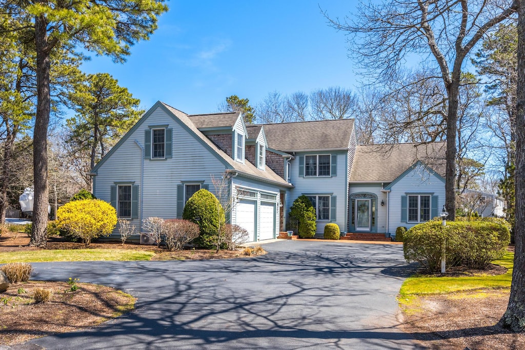 view of front of home with aphalt driveway and roof with shingles