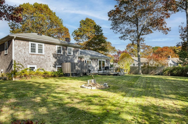 rear view of house featuring a lawn and a wooden deck