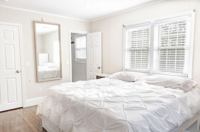 bedroom featuring wood-type flooring and ornamental molding