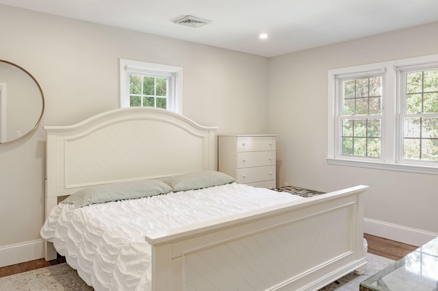 bedroom featuring hardwood / wood-style flooring and multiple windows