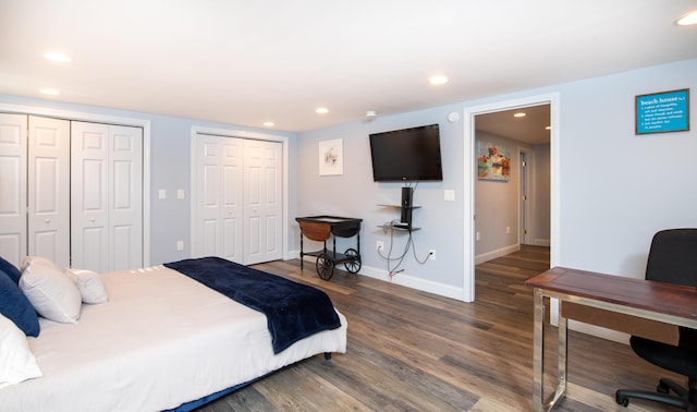 bedroom featuring multiple closets and dark hardwood / wood-style floors