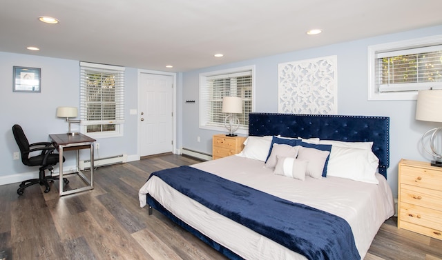 bedroom featuring baseboard heating, multiple windows, and dark hardwood / wood-style floors