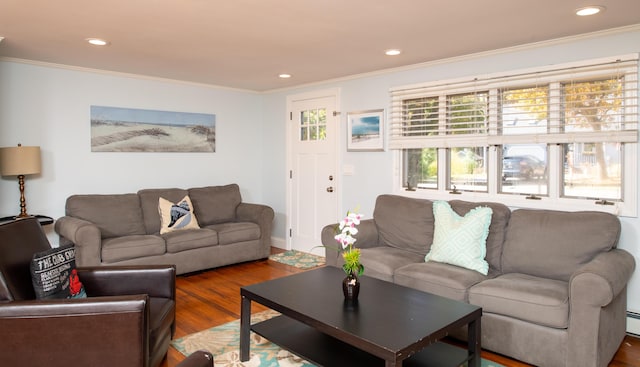 living room with wood-type flooring, baseboard heating, and crown molding