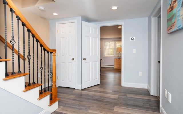 foyer entrance featuring baseboard heating and dark hardwood / wood-style flooring