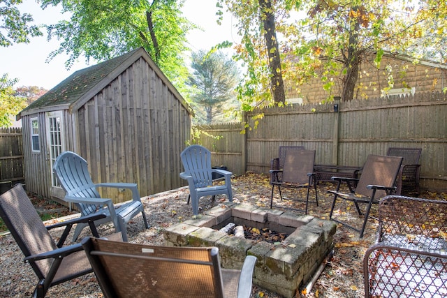 view of patio / terrace with an outdoor fire pit and a storage shed