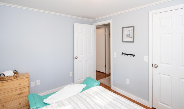 bedroom featuring ornamental molding and wood-type flooring