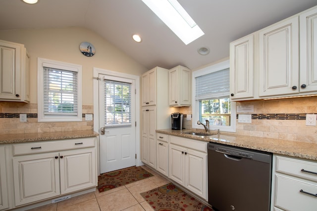 kitchen with a healthy amount of sunlight, vaulted ceiling with skylight, white cabinets, and black dishwasher