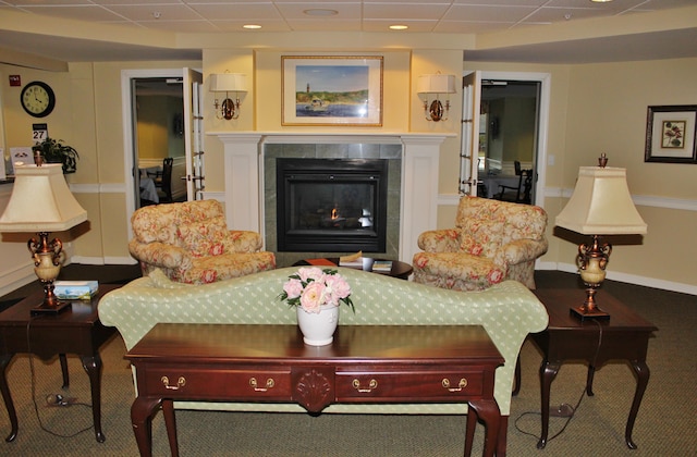 110 Dillingham Ave Unit 215U, Falmouth, MA 02540 - carpeted living room with a tile fireplace, a paneled ceiling, and baseboards