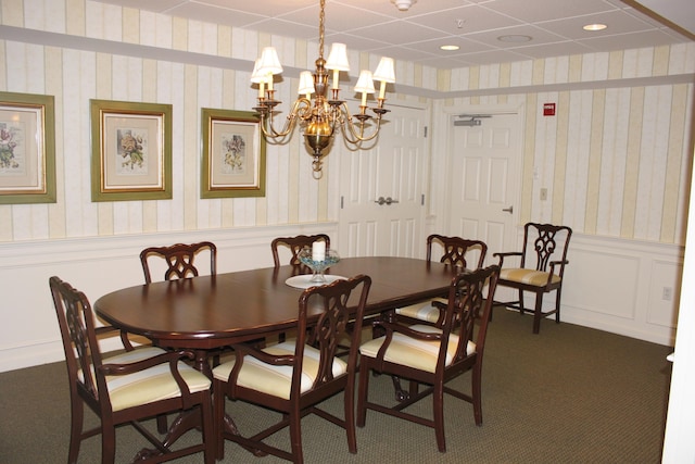 110 Dillingham Ave Unit 215U, Falmouth, MA 02540 - dining space with wainscoting, a chandelier, dark colored carpet, wallpapered walls, and a decorative wall