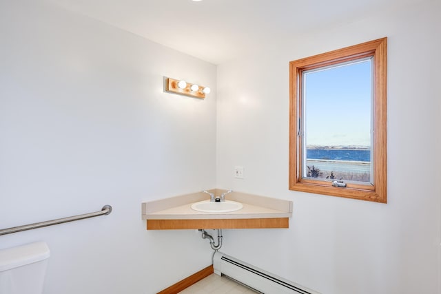 bathroom featuring sink, toilet, and a baseboard heating unit