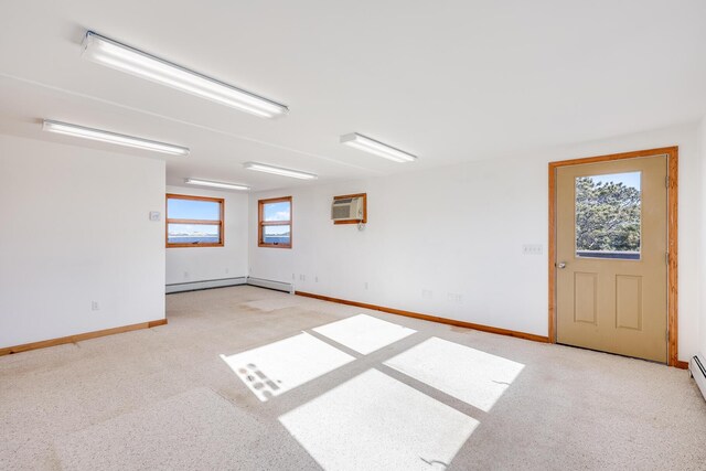 unfurnished room featuring baseboard heating and a wall mounted air conditioner