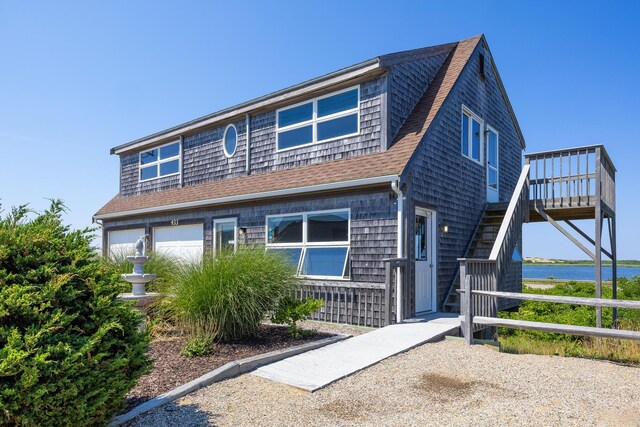 view of front of house featuring a garage and a water view