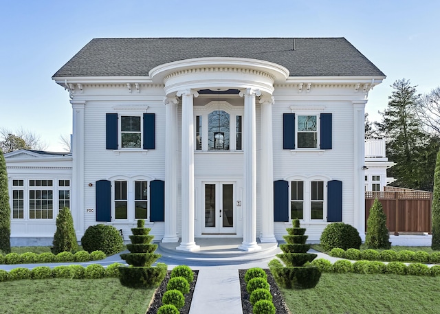 greek revival house with roof with shingles and french doors