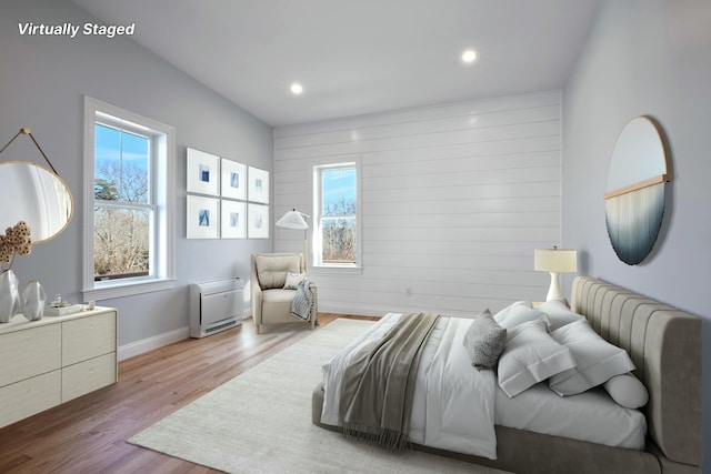 bedroom with baseboards, recessed lighting, wood finished floors, and multiple windows