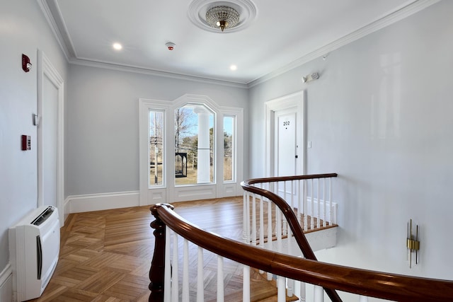 corridor with an upstairs landing, recessed lighting, ornamental molding, and baseboards