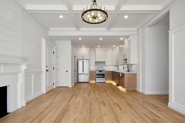 unfurnished living room featuring beamed ceiling, coffered ceiling, recessed lighting, light wood finished floors, and a notable chandelier