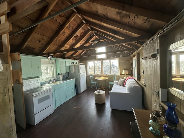 kitchen featuring white appliances, lofted ceiling with beams, dark wood-style flooring, and a wealth of natural light