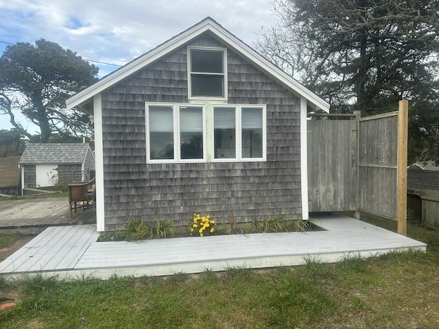 exterior space featuring an outdoor structure, a deck, and fence