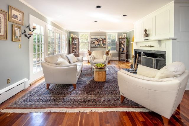 living room with ornamental molding, baseboard heating, and wood-type flooring