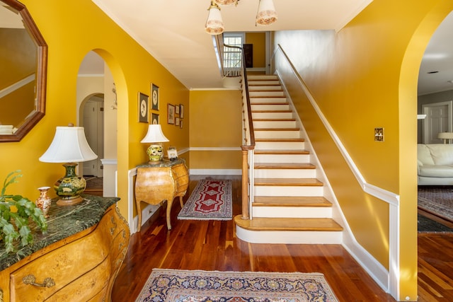 staircase featuring hardwood / wood-style flooring and crown molding