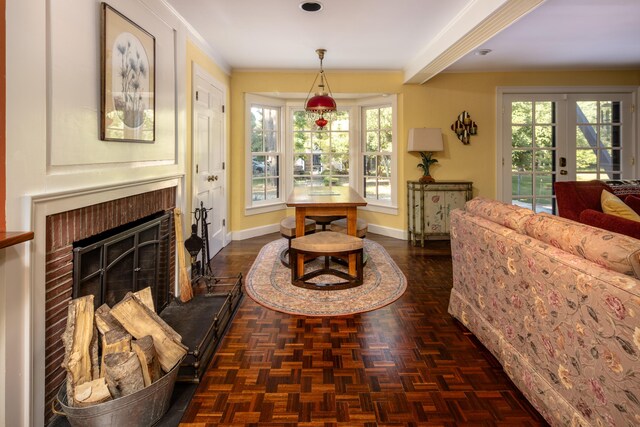 sitting room featuring a brick fireplace, plenty of natural light, crown molding, and dark parquet floors