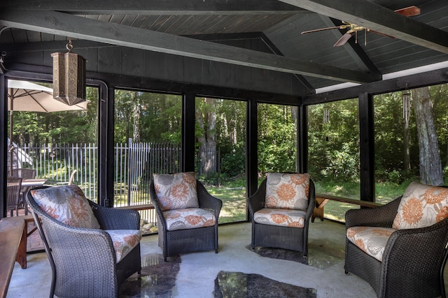 sunroom / solarium featuring ceiling fan, a healthy amount of sunlight, and lofted ceiling with beams