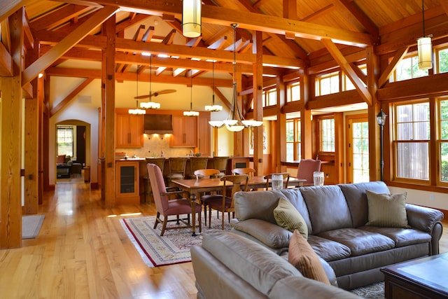 71 Stoney Hill Rd, Tisbury, MA 02568 - living area featuring light wood-style floors, a chandelier, healthy amount of natural light, a wooden ceiling with exposed beams, and arched walkways