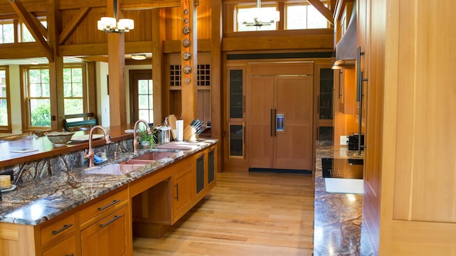 71 Stoney Hill Rd, Tisbury, MA 02568 - kitchen with paneled built in fridge, light wood finished floors, stone counters, pendant lighting, and a chandelier