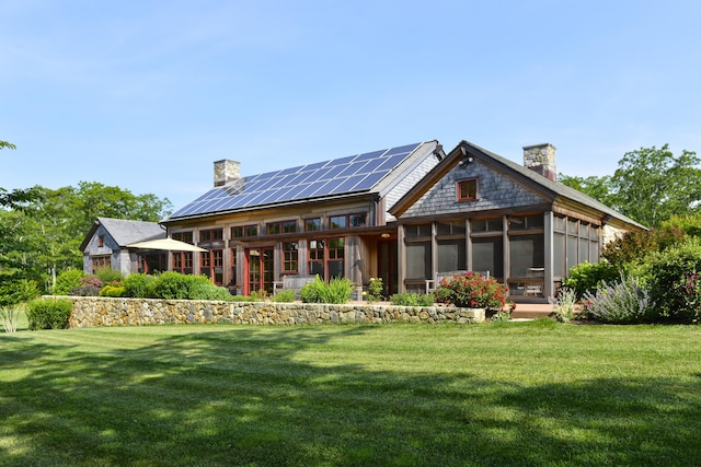 71 Stoney Hill Rd, Tisbury, MA 02568 - rear view of house with a sunroom, a chimney, roof mounted solar panels, and a yard