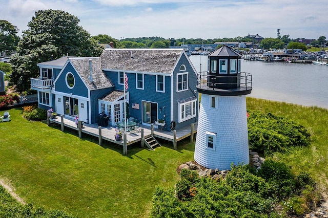 rear view of property with a lawn and a water view