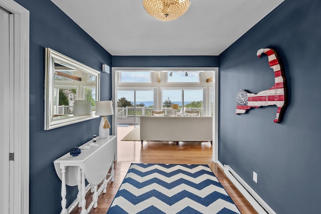 7 Dunes Rd, Harwich Port, MA 02646 - corridor featuring baseboard heating, wood finished floors, and healthy amount of natural light