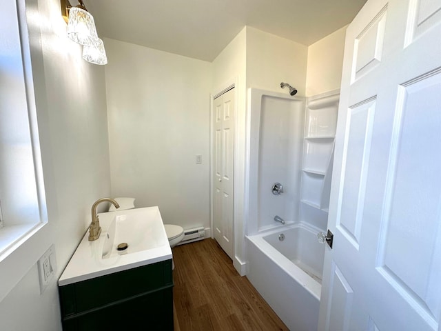 full bathroom featuring toilet, hardwood / wood-style flooring, a baseboard heating unit, shower / tub combination, and vanity