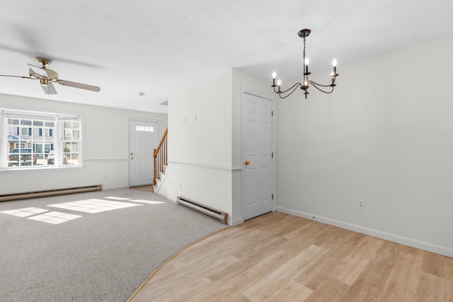 empty room featuring light colored carpet, stairway, light wood finished floors, a baseboard radiator, and baseboard heating