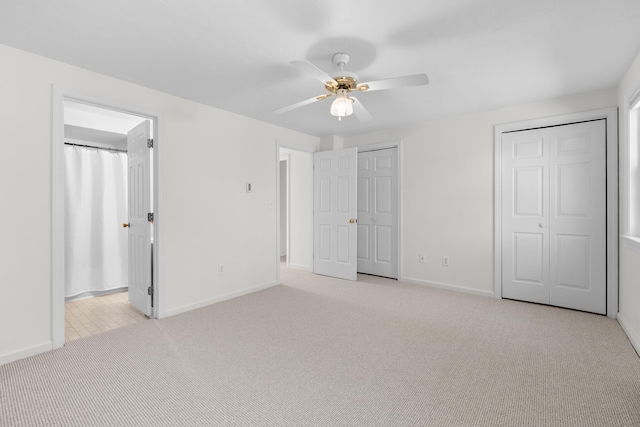 unfurnished bedroom with baseboards, multiple closets, and carpet floors