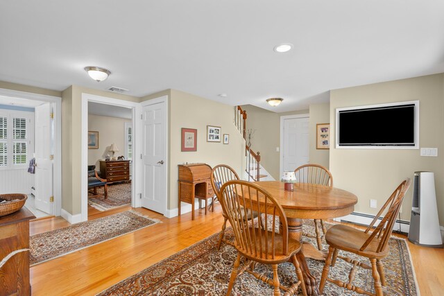 dining area with light wood finished floors, stairway, baseboards, recessed lighting, and a baseboard heating unit