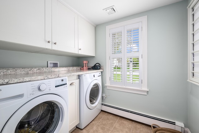 clothes washing area featuring baseboard heating, independent washer and dryer, plenty of natural light, and cabinet space