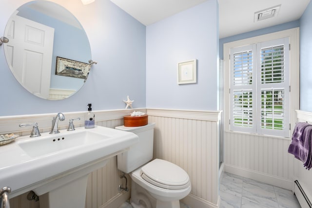bathroom with marble look tiles, a baseboard radiator, wainscoting, toilet, and a sink