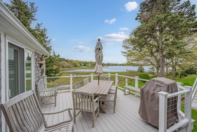 wooden terrace featuring a water view, grilling area, and outdoor dining area