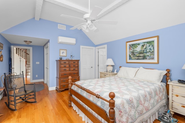 bedroom featuring a wall mounted air conditioner, light wood-style floors, baseboards, and a ceiling fan