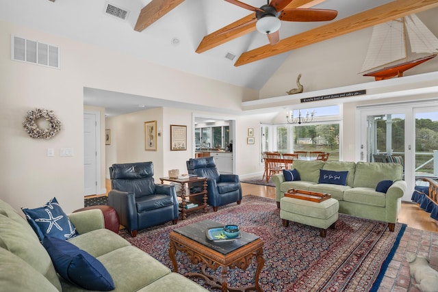 living area with beam ceiling, high vaulted ceiling, ceiling fan, and a chandelier