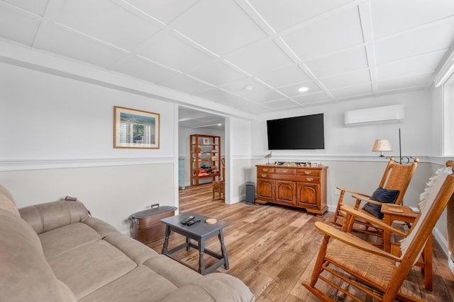 living area with an AC wall unit, light wood-type flooring, recessed lighting, and baseboards